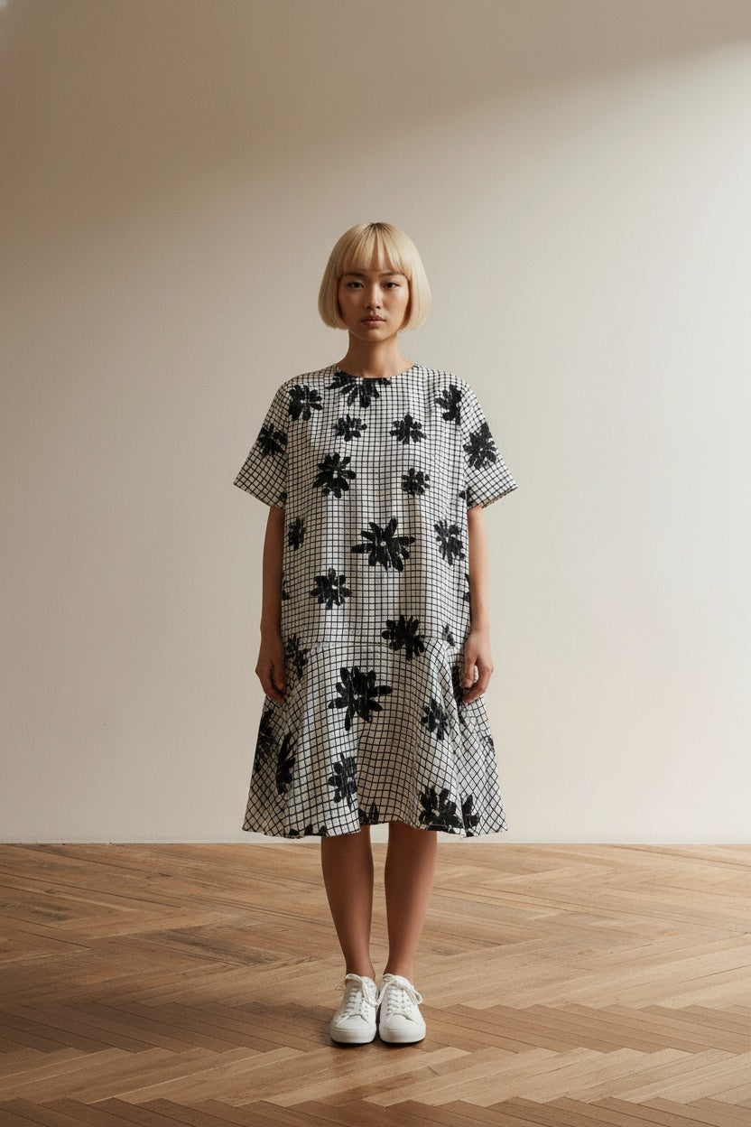 Full body view of the model wearing Essentiel Antwerp Jurk Maat 40 – Zwart-Witte Printjurk met Volantzoom en Grafisch Dessin