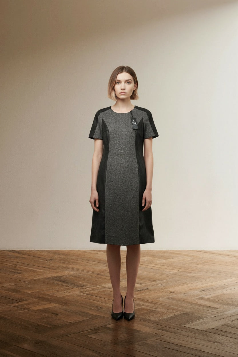 Full body view of the model wearing Luisa Cerano Jurk Maat 40/42 – Grijze Wolmix Jurk met Zwarte Leather-Look Panels | Nieuw met Kaartje