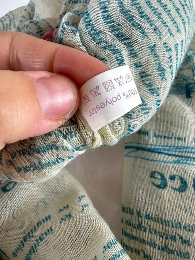 Licht mintgroene infinity sjaal met meerkleurige tekstprint, detailfoto