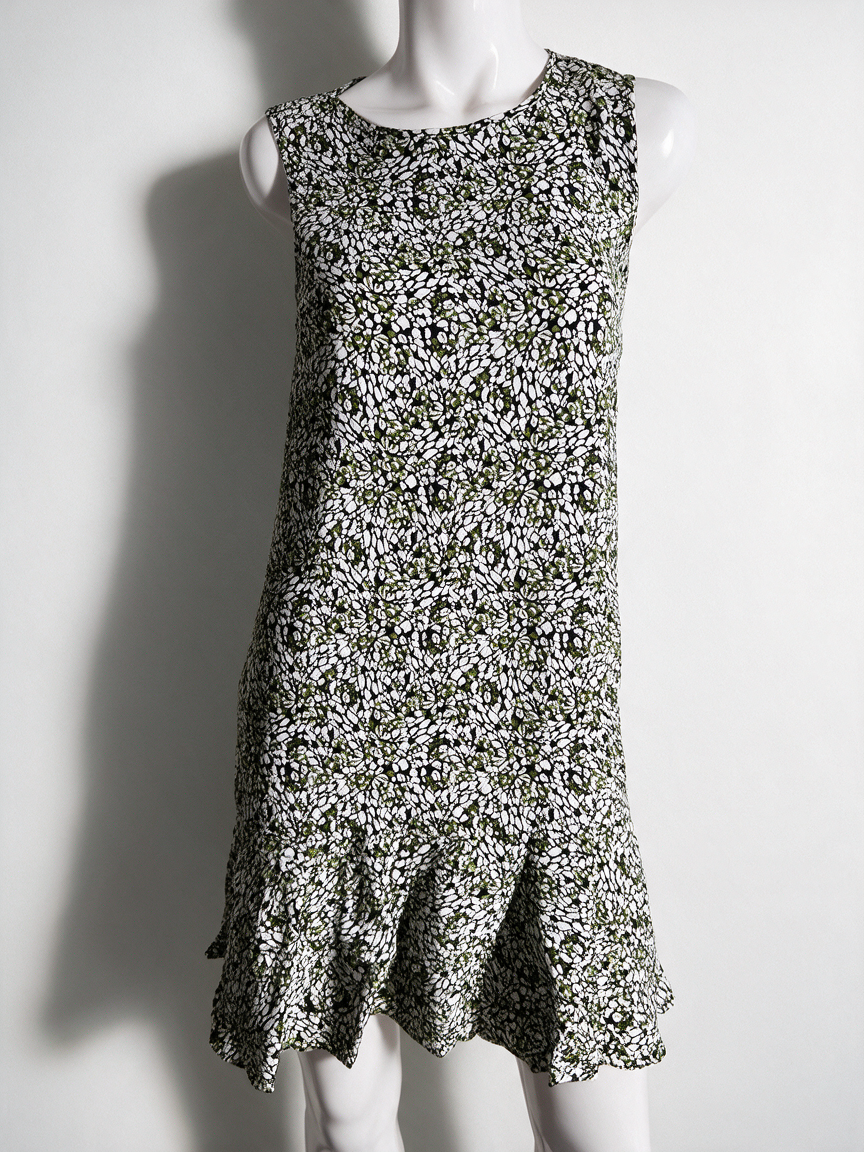 Groene mouwloze jurk met zwart-witte abstracte print en ruchezoom, voorkant op paspop
